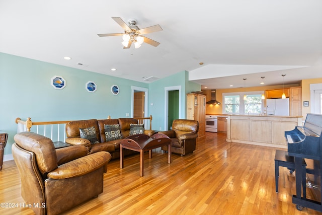 living room with light hardwood / wood-style floors, ceiling fan, and lofted ceiling