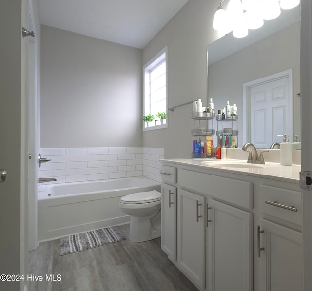 bathroom with a bathing tub, vanity, toilet, and wood-type flooring