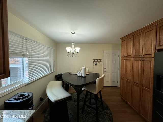 dining area featuring dark hardwood / wood-style floors and a chandelier