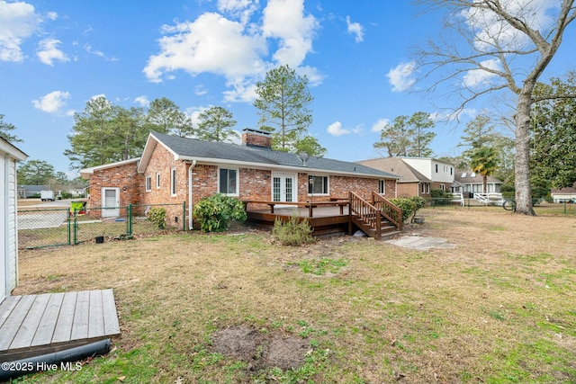 rear view of house with a yard and a wooden deck