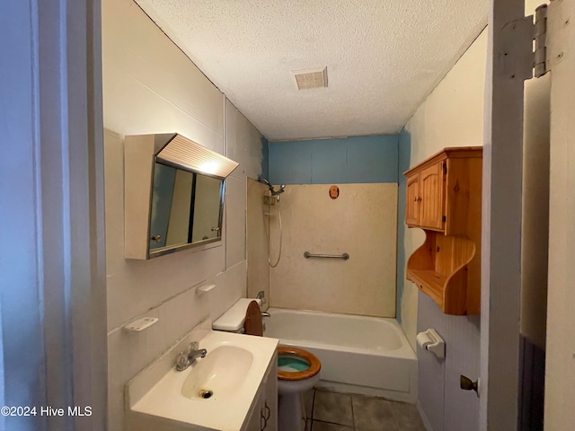 full bathroom with vanity, tile patterned floors, tiled shower / bath, toilet, and a textured ceiling