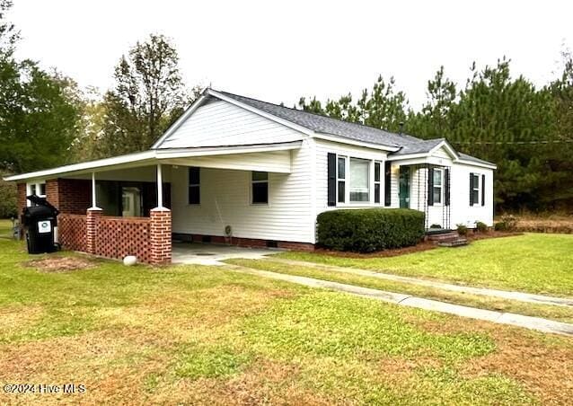 view of front facade with a front lawn and a carport