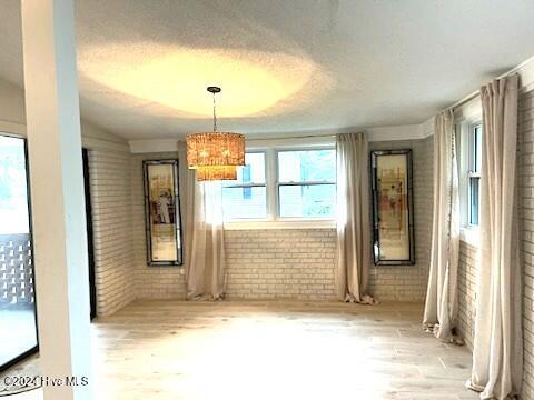 interior space featuring light hardwood / wood-style floors and brick wall