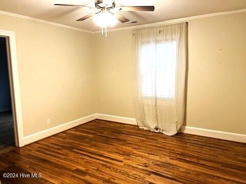 empty room featuring dark hardwood / wood-style floors, ceiling fan, and ornamental molding