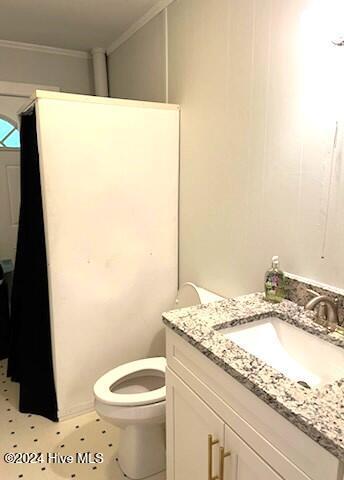 bathroom with vanity, toilet, and ornamental molding