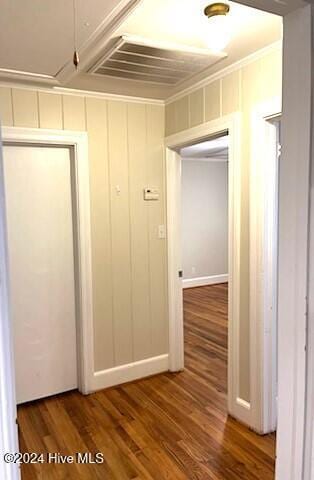 hall with wood-type flooring and ornamental molding