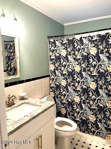 bathroom with curtained shower, toilet, vanity, and ornamental molding