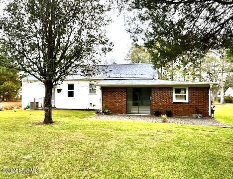 rear view of house featuring a yard