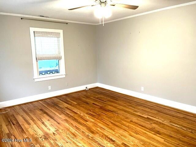 spare room featuring crown molding, hardwood / wood-style floors, and ceiling fan