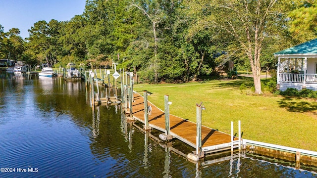 dock area featuring a lawn and a water view