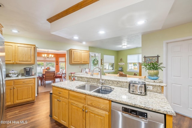 kitchen featuring dark hardwood / wood-style flooring, stainless steel appliances, a kitchen island with sink, sink, and an inviting chandelier