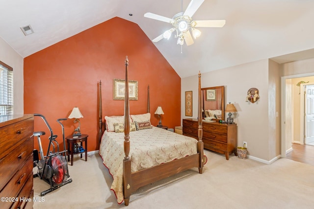 bedroom with ceiling fan, light colored carpet, and vaulted ceiling