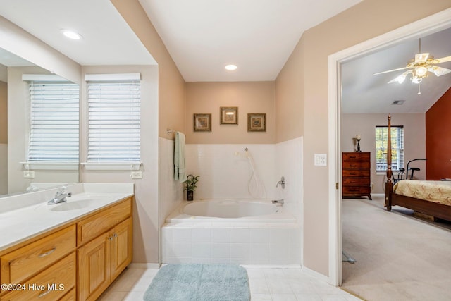 bathroom featuring tile patterned flooring, vanity, ceiling fan, and tiled tub