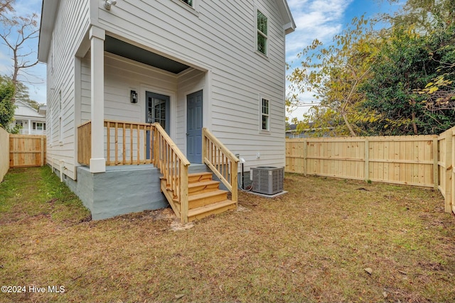 exterior space with central AC unit and a lawn