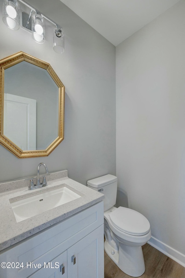 bathroom with vanity, toilet, and wood-type flooring