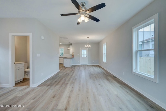 unfurnished living room with ceiling fan with notable chandelier and light wood-type flooring