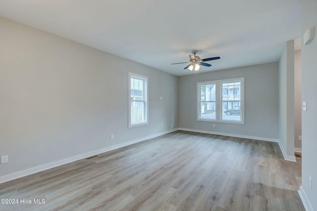 unfurnished room featuring ceiling fan, light wood-type flooring, and a wealth of natural light