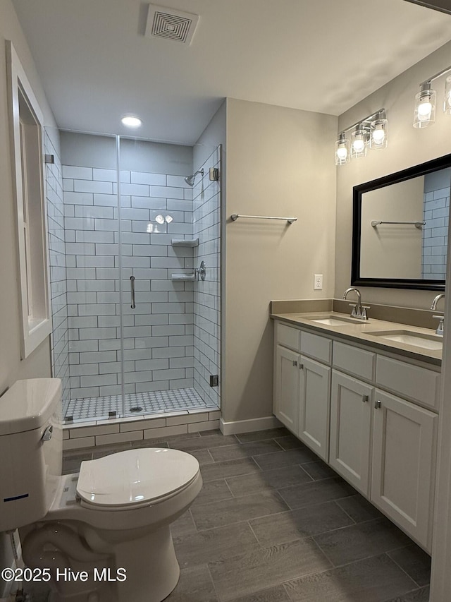 bathroom featuring vanity, toilet, and a shower with door