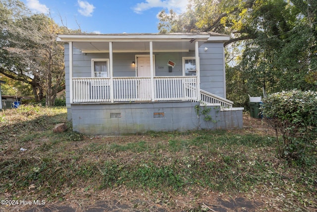 bungalow-style house with a porch and crawl space