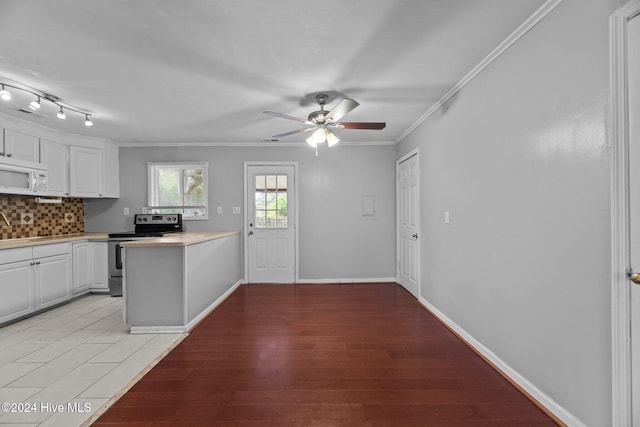 kitchen with white cabinetry, tasteful backsplash, stainless steel electric range, ornamental molding, and light hardwood / wood-style flooring