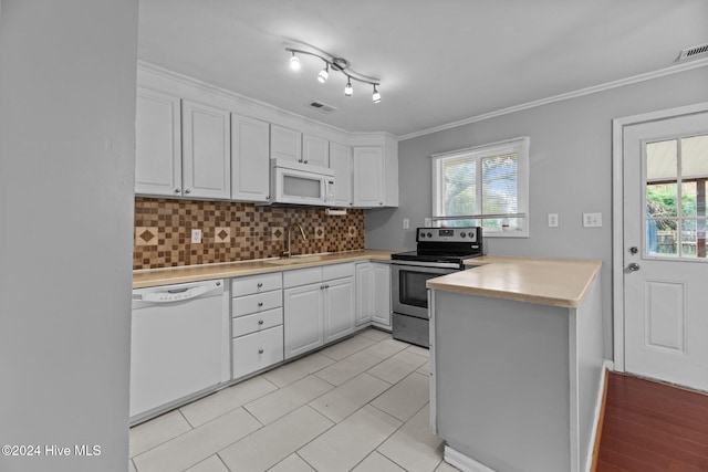 kitchen with white appliances, white cabinets, kitchen peninsula, and crown molding