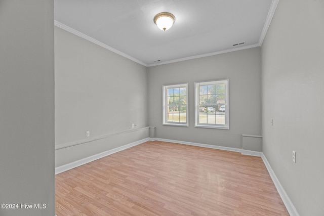 unfurnished room featuring light wood-type flooring and crown molding