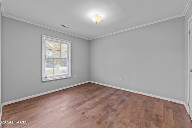 empty room featuring crown molding and hardwood / wood-style floors