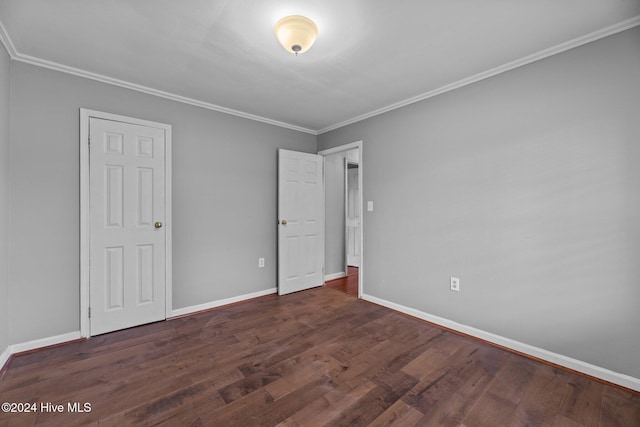 unfurnished bedroom with dark hardwood / wood-style flooring and crown molding