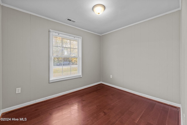 empty room with crown molding and hardwood / wood-style flooring