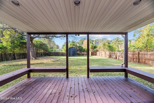 wooden deck featuring a yard and a shed