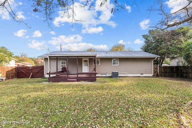 rear view of house featuring a wooden deck, a yard, and central AC