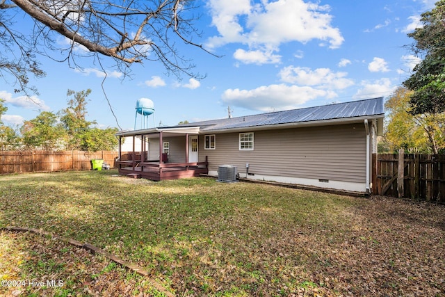 back of house featuring a deck, central AC, and a yard