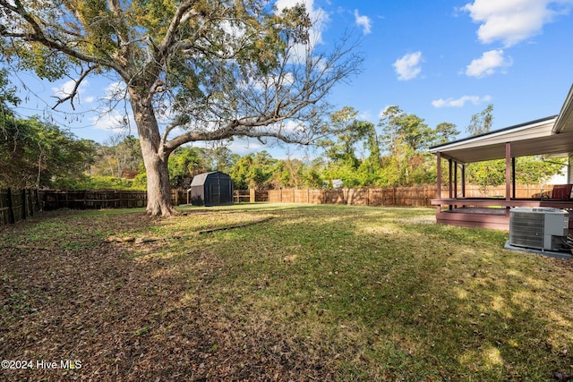 view of yard featuring central AC unit and a storage shed