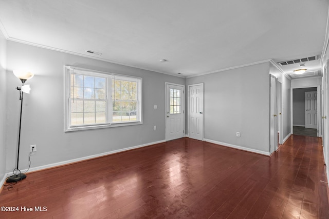 spare room featuring crown molding and dark hardwood / wood-style floors