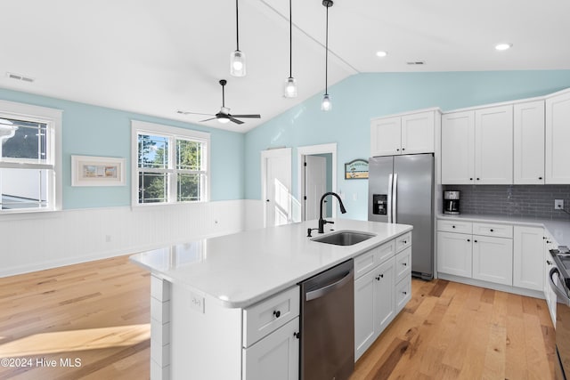 kitchen with white cabinetry, appliances with stainless steel finishes, a kitchen island with sink, and sink