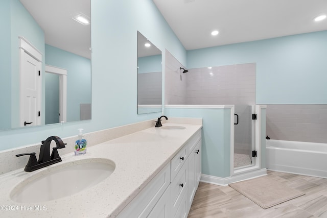 bathroom with plus walk in shower, hardwood / wood-style floors, and vanity