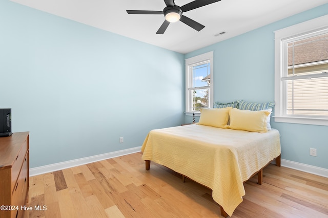 bedroom with light hardwood / wood-style flooring and ceiling fan