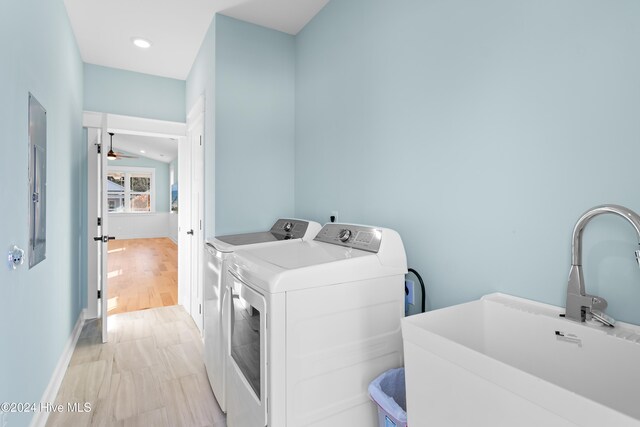 laundry room with sink, independent washer and dryer, ceiling fan, and light wood-type flooring