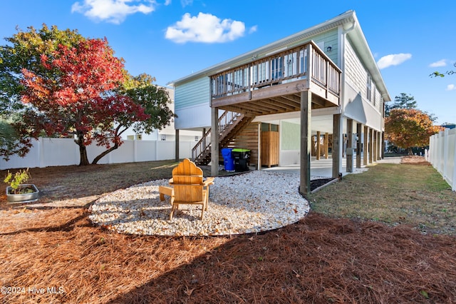 rear view of property with a wooden deck, a yard, and a patio area