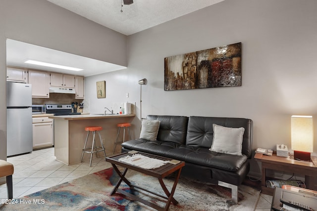 tiled living room featuring a textured ceiling