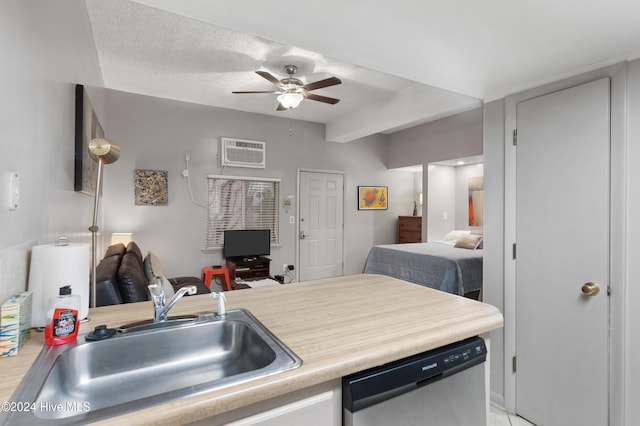 kitchen with ceiling fan, sink, stainless steel dishwasher, an AC wall unit, and a textured ceiling