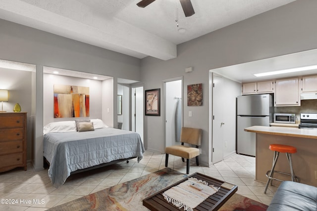 bedroom with light tile patterned floors, a textured ceiling, stainless steel refrigerator, and ceiling fan