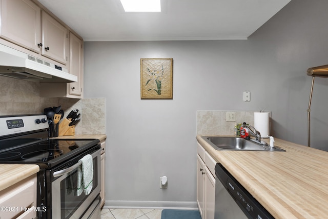 kitchen featuring backsplash, sink, light tile patterned floors, and stainless steel appliances