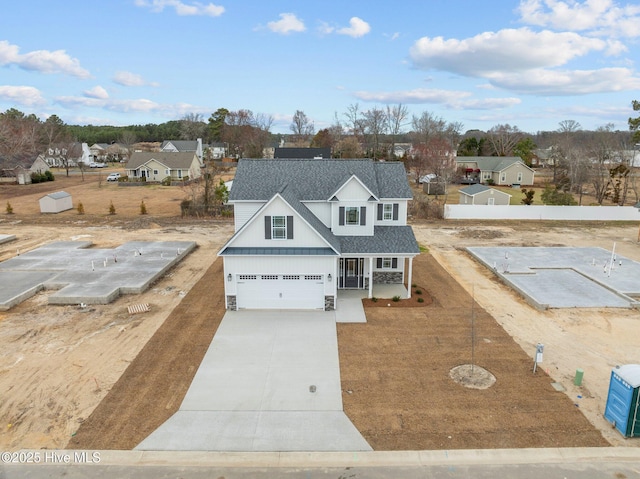 view of front facade with driveway, a shingled roof, fence, a porch, and board and batten siding