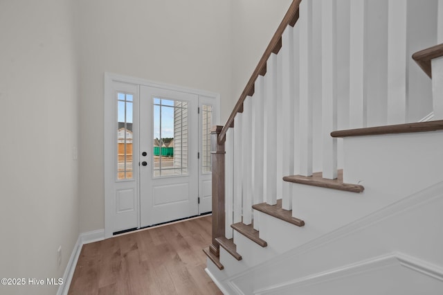 foyer featuring stairs, baseboards, and wood finished floors