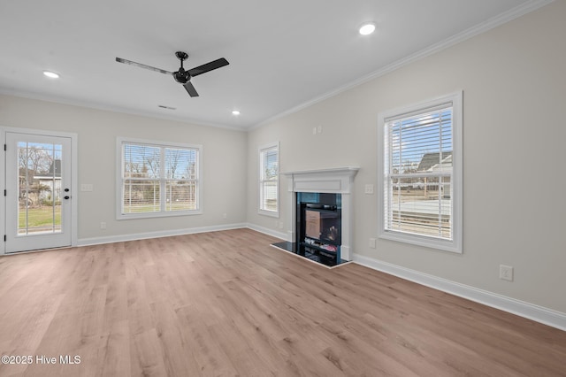 unfurnished living room with light wood finished floors, baseboards, a ceiling fan, crown molding, and a fireplace