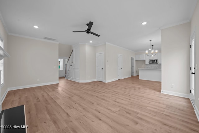 unfurnished living room with ceiling fan with notable chandelier, baseboards, stairs, light wood-style floors, and ornamental molding