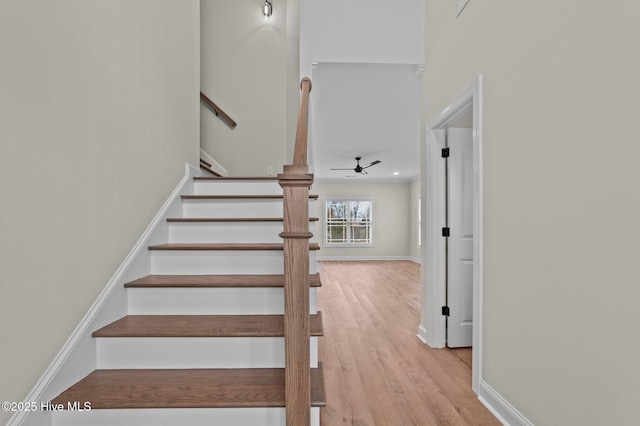 stairway with baseboards, a ceiling fan, and wood finished floors