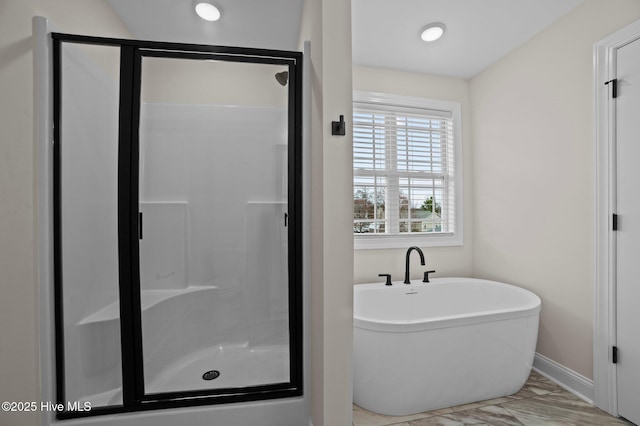 full bath with a stall shower, baseboards, marble finish floor, and a freestanding bath