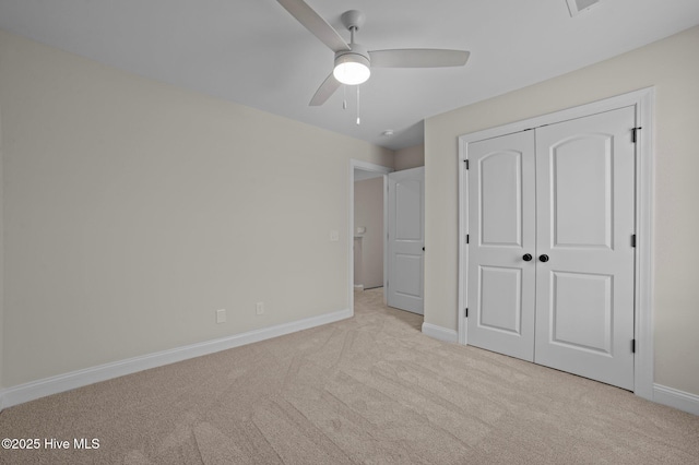 unfurnished bedroom featuring baseboards, a closet, and light colored carpet